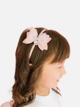 Diadema con lazo brillante y colgante de corazón de Sweet Wink